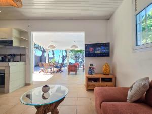 a living room with a couch and a table at Villa Ti Kay Paradi - Accès plage direct in Saint-Pierre