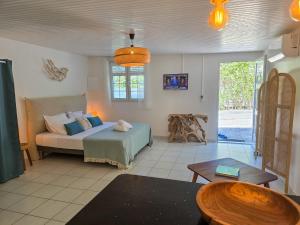 a living room with a bed and a table at Villa Ti Kay Paradi - Accès plage direct in Saint-Pierre