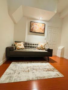 a living room with a couch and a painting on the wall at Cozy Walkout Basement with Tranquility in Toronto