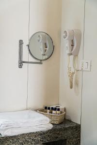 a room with a mirror and a phone on the wall at Bonaparte Hotel - Excelente Apartamento#1402 in Brasilia