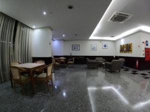 a waiting room with tables and chairs in a building at Bonaparte Hotel - Excelente Apartamento#1402 in Brasilia