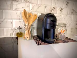 a kitchen counter with a coffee maker and wooden utensils at Le Chalet Urbain - Montélimar in Montélimar