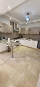a large kitchen with a table in the middle at Maison indépendante in Hammamet Nord