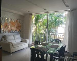 ein Wohnzimmer mit einem Tisch und einem Sofa in der Unterkunft Upar Suite Apartamento con Aire Acondicionado y piscina in Valledupar