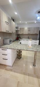 a kitchen with white cabinets and a granite counter top at Maison indépendante in Hammamet Nord +23 photos