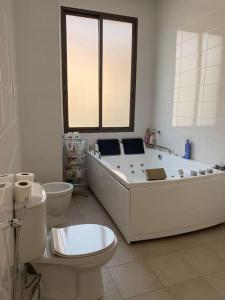 a bathroom with a tub and a toilet and a sink at Pepek Home in Patriota, Talatona in Luanda