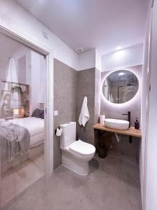 a bathroom with a toilet and a sink and a bed at La Brisa Lofts in Valencia