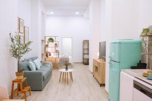 a living room with a blue couch and a kitchen at La Brisa Lofts in Valencia
