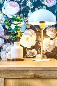 a table with a lamp and a plant in a vase at GioEstate Holiday, with Free Parking, Flat28 in Brighton & Hove