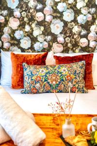 a bedroom with a bed with pillows and a floral wall at GioEstate Holiday, with Free Parking, Flat28 in Brighton & Hove