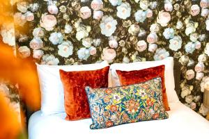 a bed with three pillows and a floral wall at GioEstate Holiday, with Free Parking, Flat28 in Brighton & Hove