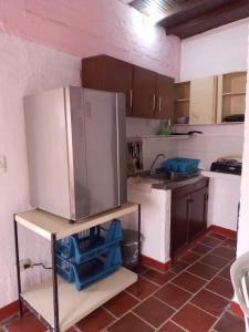 a kitchen with a refrigerator sitting on a shelf at Descanso en el Campo in Cali +14 photos