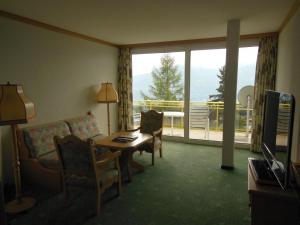 a living room with a couch and a table and a window at Grand Hôtel du Parc in Crans-Montana