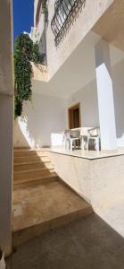 a stairway with chairs and a table in a building at Maison indépendante in Hammamet Nord