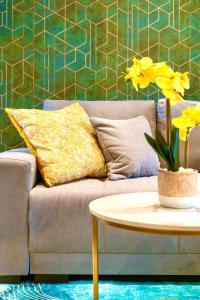 a living room with a couch and a table with yellow flowers at GioEstate Holiday, with Free Parking, Flat28 in Brighton & Hove