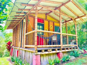 Casa con estructura de madera y porche en Cabañas Los Gulungos Lodge, en Jardín