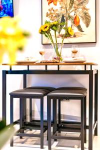 a table with two stools and a table with glasses of wine at GioEstate Holiday, with Free Parking, Flat28 in Brighton & Hove