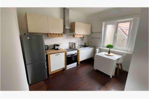 a small kitchen with a refrigerator and a table at Trendy studio at top location in Antwerp