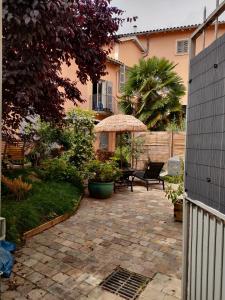 a patio with two chairs and an umbrella at La Chamade en Beaujolais in Anse