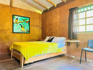 Un dormitorio con una cama amarilla y una ventana. en Cabañas Los Gulungos Lodge, en Jardín