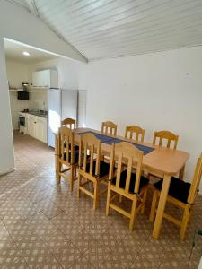a kitchen with a wooden table and wooden chairs at Casa da Lua Centro in Búzios