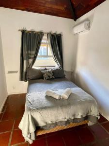 a bedroom with a bed with two towels on it at Casa da Lua Centro in Búzios