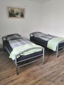 two twin beds in a room with wooden floors at Monteurzimmer und Reisende in Salzgitter +5 photos