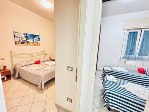 ein kleines Zimmer mit zwei Betten und einem Fenster in der Unterkunft Viareggio on the Beach - Apartment in Viareggio