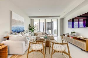 Una sala de estar con un sofá, una mesa y sillas. en Ocean Views and Pool Access Riviera Beach Condo!, en Riviera Beach