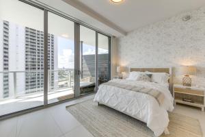 Un dormitorio con una cama grande y grandes ventanales. en Ocean Views and Pool Access Riviera Beach Condo!, en Riviera Beach 24 fotos más
