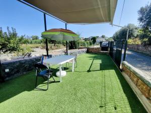 a table with an umbrella and chairs on a patio at Casa Amazonia PT - quarto águas in Casconha +29 photos