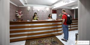 a man standing at a bar with two women at Airport Hotel in New Delhi