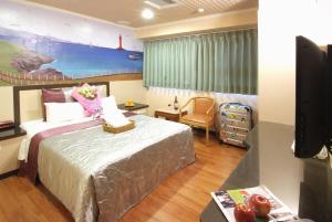 a hotel room with a bed and a tv at Left Bank Hotel in Hsinchu City