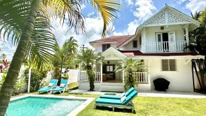a house with a swimming pool and blue chairs at Villa 4Bdrms 3.5baths with pool, Jacuzzi and Starlink WiFi in Las Terrenas