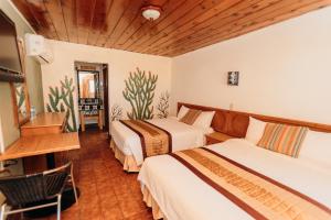 a hotel room with two beds and a television at Hotel Las Palmas in San Felipe