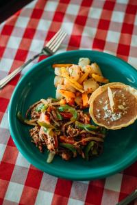 a green plate of food with a sandwich and fries at Hotel Las Palmas in San Felipe