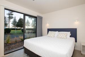 Postel nebo postele na pokoji v ubytování Waikanae Beach Ocean View Apartments