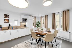 a white kitchen with a wooden table and chairs at INhome - Zentral - Küche - TV - Netflix in Schwäbisch Hall