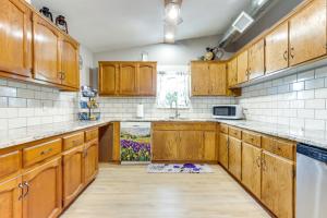 a kitchen with wooden cabinets and a sink at 4 Mi to Pomme De Terre Lake Large Home with Patio! in Galmey