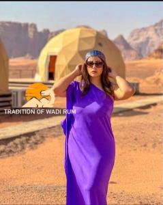 a woman in a purple dress standing in the desert at Traditions of Wadi Rum camp & jeep tour in Wadi Rum