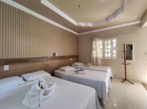 ein Zimmer mit zwei Betten und einem Fenster in der Unterkunft Pousada Porto dos Corais in Maragogi + 40 Fotos