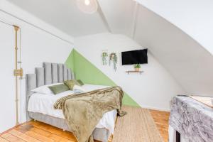 a white room with a bed and a tv at Le Végétal - Cosyloc Agency - Centre historique in Vincennes