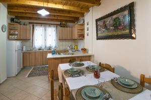 a kitchen with a table and chairs in a room at Athina's House in Alónai