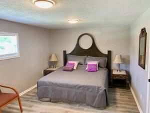 ein Schlafzimmer mit einem Bett mit zwei rosa Kissen in der Unterkunft Getaway Clubhouse in Winter Haven