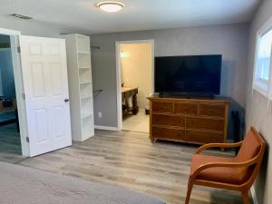 ein Wohnzimmer mit einem Flachbild-TV auf einer Kommode in der Unterkunft Getaway Clubhouse in Winter Haven + 31 Fotos