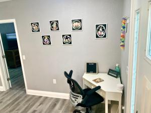 Zimmer mit einem Schreibtisch, einem Stuhl und Bildern an der Wand in der Unterkunft Getaway Clubhouse in Winter Haven