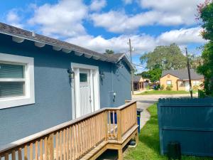 ein blaues Haus mit einer Holzterrasse im Hof in der Unterkunft Getaway Clubhouse in Winter Haven