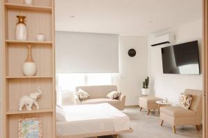 un soggiorno bianco con letto e divano di Cozy apartment next to the beach! a Gaira Altre 33 foto
