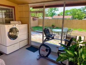 a screened in porch with a washing machine and a table at Sweet Cottage in Winter Haven