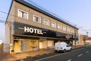 a white van parked in front of a hotel at Euro Hotel in Ubiratã